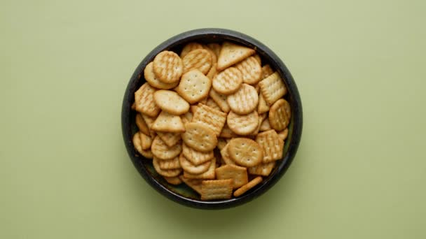 Top View Spinning Bowl Salty Crackers Isolated Olive Background — Stock Video