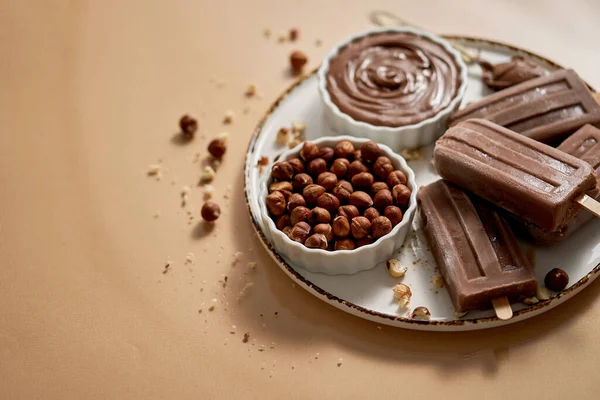 Chocolate Popsicles Hazelnuts Served Melted Chocolate White Plate Top View — Φωτογραφία Αρχείου