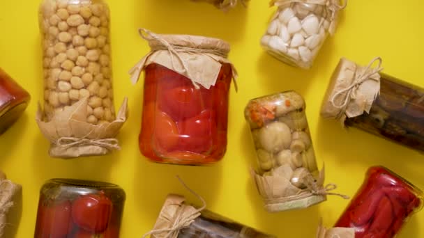 各种蔬菜和蘑菇在玻璃瓶中保存 放在黄色的背景上 — 图库视频影像