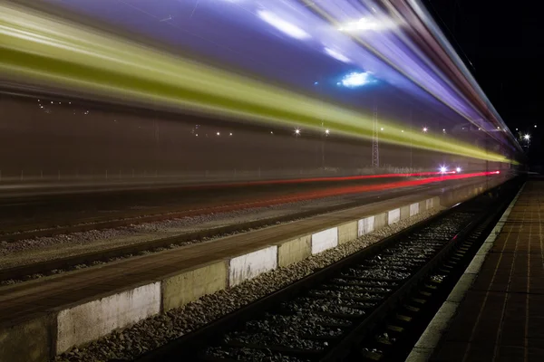 Comboio vermelho e azul deixando uma pequena estação ferroviária holandesa sem telhado — Fotografia de Stock