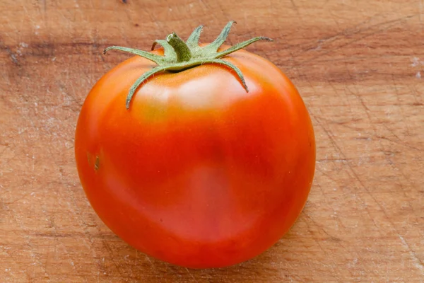 Tomate fresco na placa de corte de madeira — Fotografia de Stock