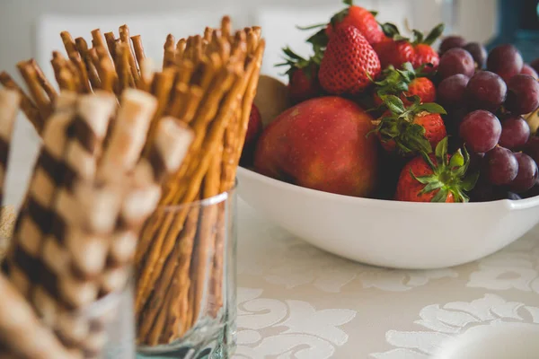 salty sticks and some sweet tubes in fornt of a bowl with fresh and healty food