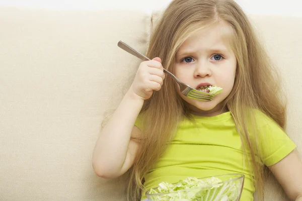 Little girl eats green meal — Stock Photo, Image