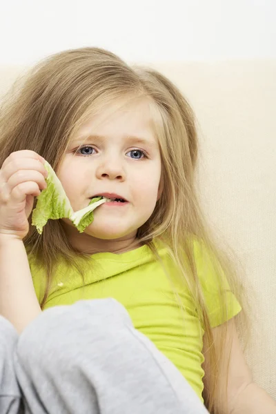 Little girl eats green meal — Stock Photo, Image