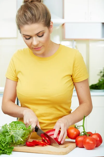 Donna con cibo vegetariano in piedi contro la cucina di casa — Foto Stock