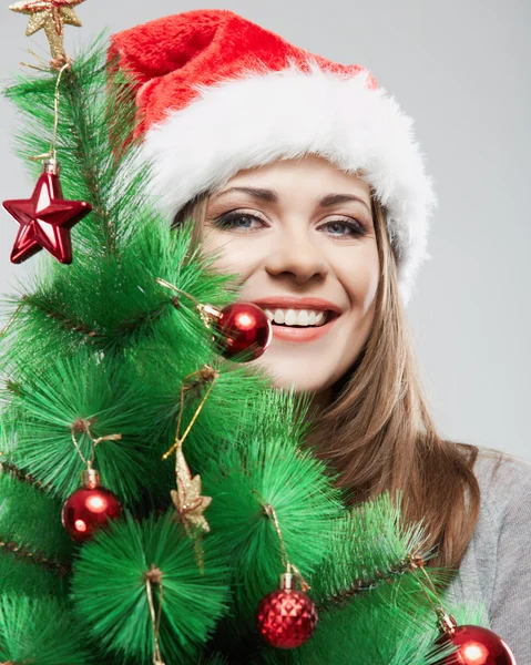Woman in santa hat holding christmas tree — Stock Photo, Image