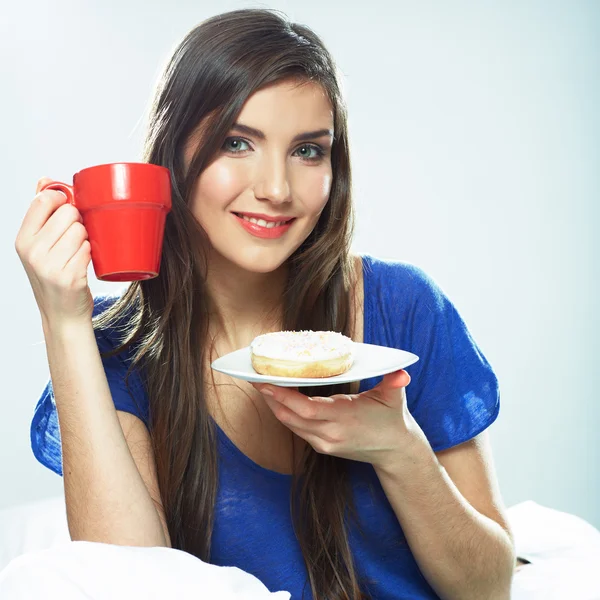 Woman drinking and eating in bed — Stock Photo, Image