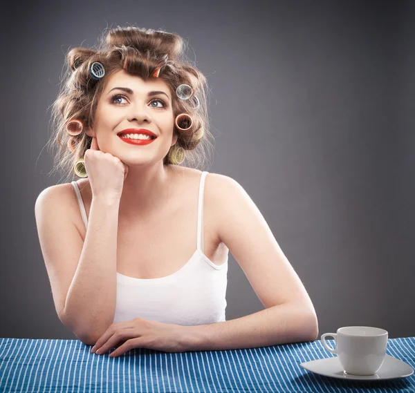 Young woman with curlers and cup of coffee — Stock Photo, Image