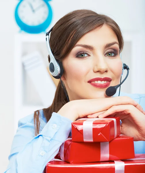 Smiling operator seat at table with red gift box. Happy busines — Stock Photo, Image