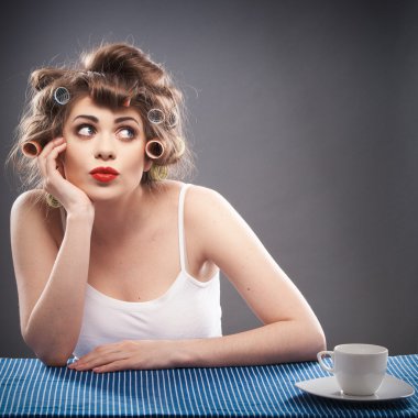 curlers ve kahve ile genç kadın