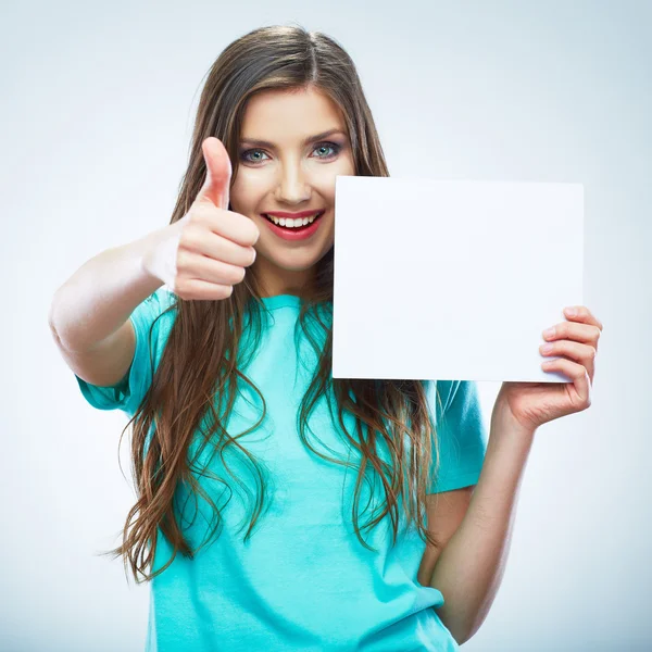 Dospívající dívka drží bílý prázdný papír. mladý usmívající se žena show — Stock fotografie