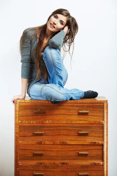 Young model seating at cupboard for clothes. — Stock Photo, Image