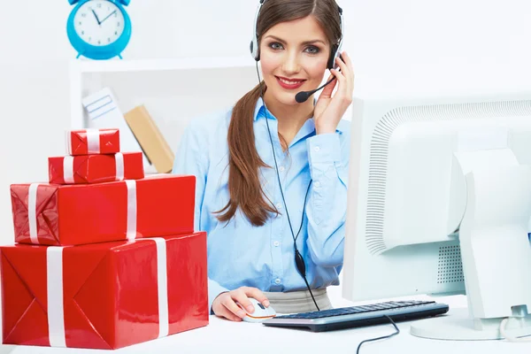 Smiling operator seat at table with red gift box. — Stock Photo, Image