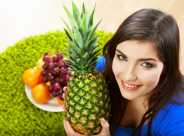 Vrouw zitplaatsen op verdieping met vruchten. — Stockfoto