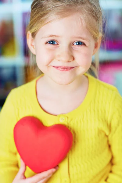 Holčička drží červené srdce. — Stock fotografie