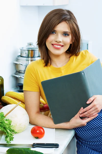 Cooking woman standing in kitchen, reed recipe from menu — Stock Photo, Image