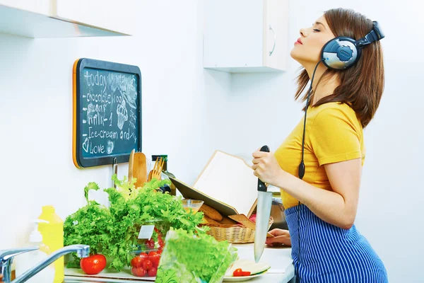 Mulher na cozinha cozinhar com música ouvindo — Fotografia de Stock