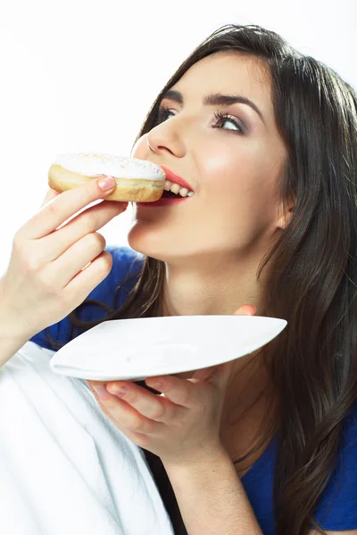 Woman eating donut in bed. — Stock Photo, Image