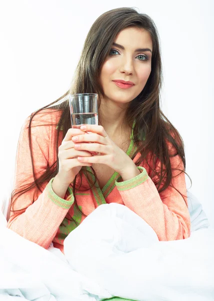 Lächelnde Frau im Bett hält Wasserglas. — Stockfoto