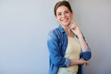 Mavi gömlekli mutlu kadın düşünüyor ve gülümsüyor..