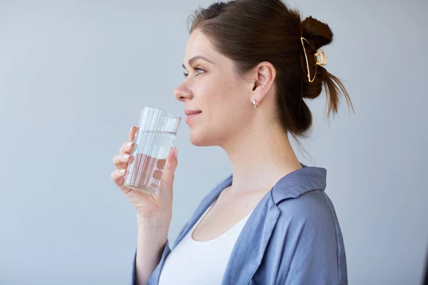 Woman drinking water from glass. isolated portrait.