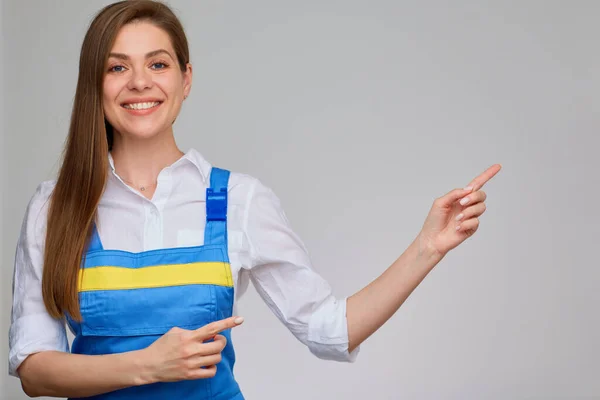 Mavi Üniformalı Gülümseyen Kadın Boş Fotokopi Alanını Işaret Ediyor — Stok fotoğraf