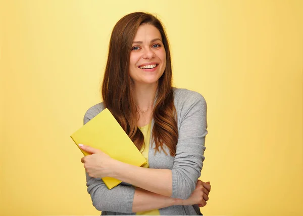 Smiling woman teacher or student holding books. isolated female portrait on yellow background. Smiling  girl with long hair.