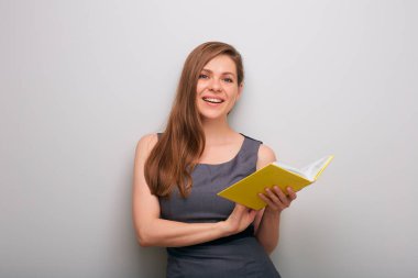 Açık sarı kitabı olan mutlu, gülümseyen iş kadını. münzevi kadın iş adamı portresi.