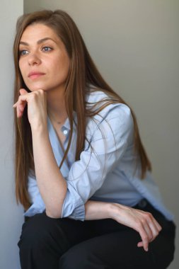 Ciddi odaklı kadın çene dokunur, duvarın yanında oturur.. 