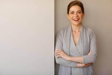 İş kadını kollarını kavuşturup iş elbisesi giyiyor..