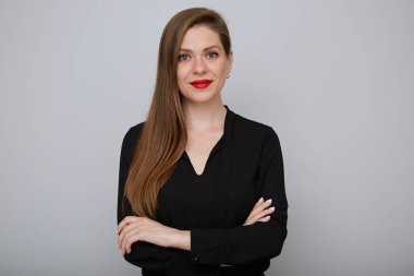 Uzun siyah tişörtlü, gülümseyen genç bir iş kadını kollarını kavuşturmuş, izole edilmiş bir kadın portresi..