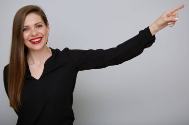 Siyah takım elbiseli, gülümseyen bir iş kadını, kırmızı dudaklı ve uzun saçlı mutlu bir kızın izole edilmiş portresini işaret ediyor..