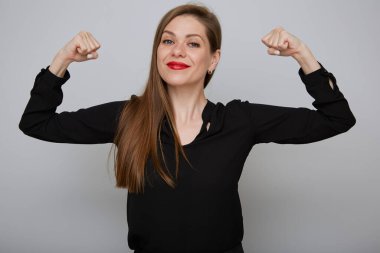 İzole kadın güç konsepti portresi. Gülümseyen iş kadını kollarını büküyor..