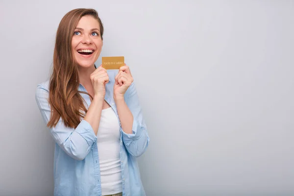 手里拿着信用卡的快乐的笑着的女人 长长的头发穿着蓝色的白衬衫 望着孤立的肖像 — 图库照片