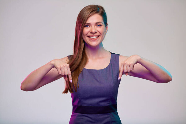 Улыбающаяся деловая женщина, указывающая пальцем вниз, изолированный портрет.