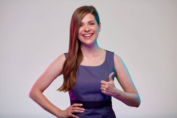 Улыбающаяся деловая женщина, показывающая большой палец. Женщина бизнесмен с длинными волосами в сером платье изолированный портрет.