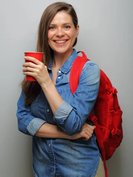 赤いバックパックとコーヒーグラスで笑顔の女性学生 孤立した女性の肖像 — ストック写真