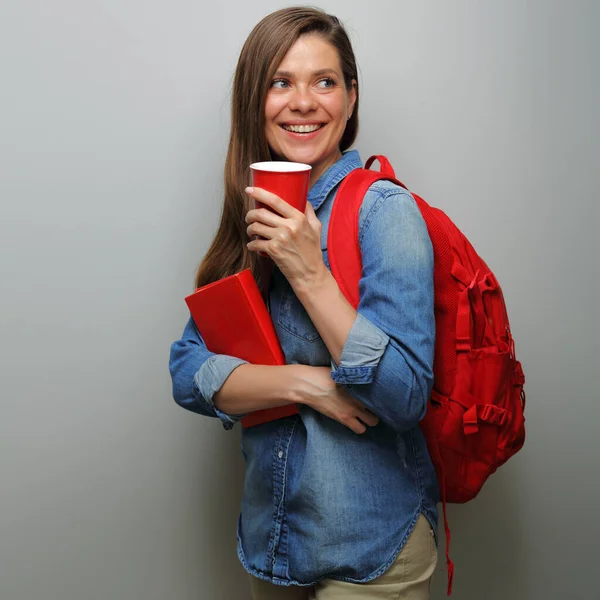 Woman student with red backpack, red book coffee glass looking back over shoulder. isolated female portrait.