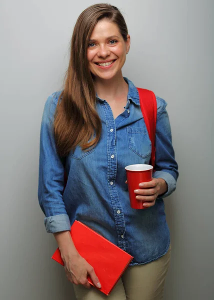 Smiling woman student with red backpack, red book and coffee glass. isolated female portrait.