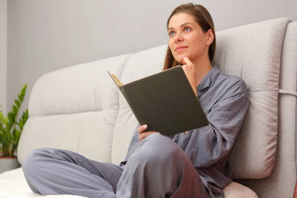 Ruhige Und Träumende Frau Sitzt Auf Dem Bett Und Hält — Stockfoto