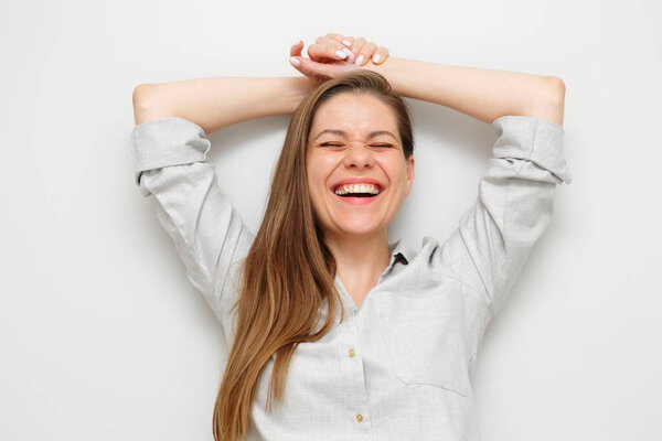 Happy laughing woman with closed eyes holding hands behind her head smiling and resting. Isolated female portrait.