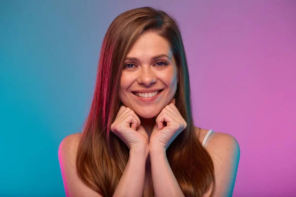 Smilng happy woman leaned face on her hands, portrait with neon lights colors effect. Girl isolated on neon background