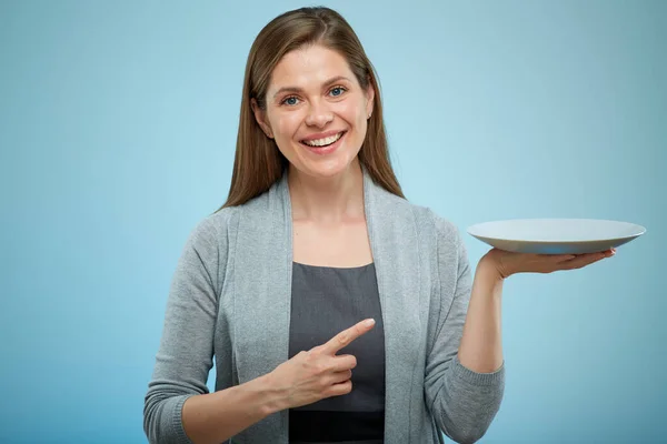 Leende Kvinna Som Håller Tom Tallrik Och Pekar Finger Isolerat — Stockfoto