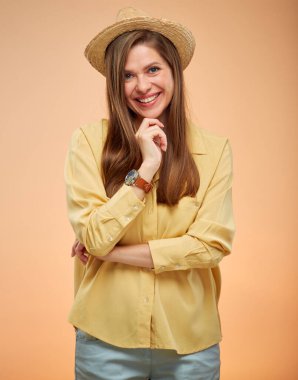 Stüdyo sarı arka planda izole edilmiş, yaz şapkalı gülümseyen kadın..