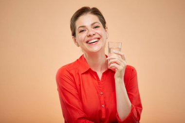 Kırmızı tişörtlü, su bardağıyla gülümseyen bir kadın portresi..