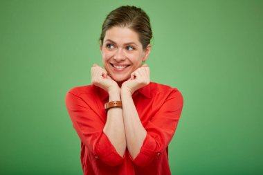 Kırmızı tişörtlü gülümseyen kadın yeşilde izole edilmiş portreye bakıyor..