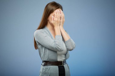 Depresyondaki kadın, elleri suratında. Mavi üzerine izole edilmiş kadın portresi.