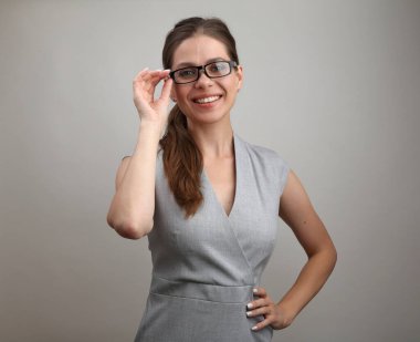 Gülümseyen kadın öğretmen gözlüklerine dokunuyor. İş kadını portresi.