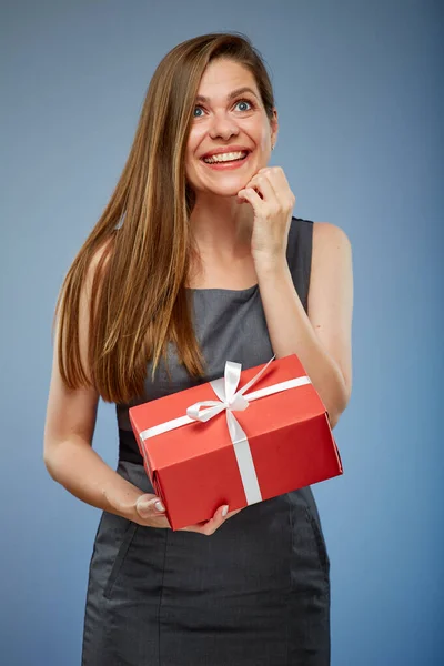 Smiling business woman with red gift box looking up studio isolated portrait on blue.