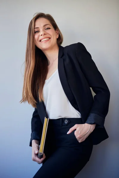 Woman  teacher in black business suit and white shirt keeps hand in pants pocket. isolated profile portrait.